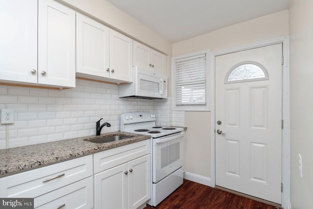 kitchen with white cabinetry, white appliances, backsplash, and a sink