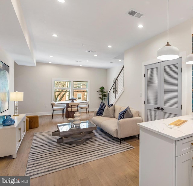 living room with recessed lighting, visible vents, and light wood-style flooring