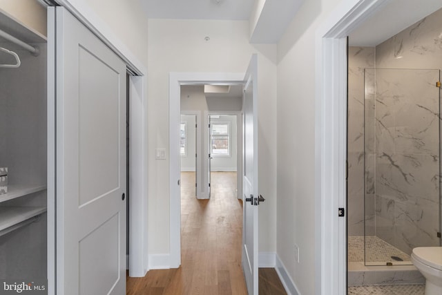 hallway with baseboards and wood finished floors