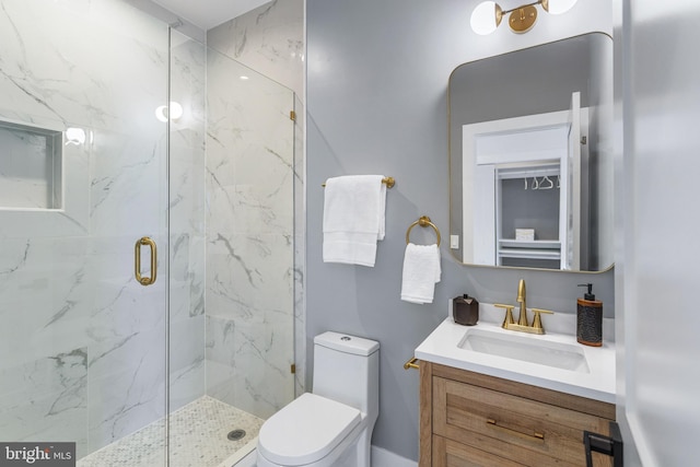 bathroom featuring a marble finish shower, toilet, and vanity