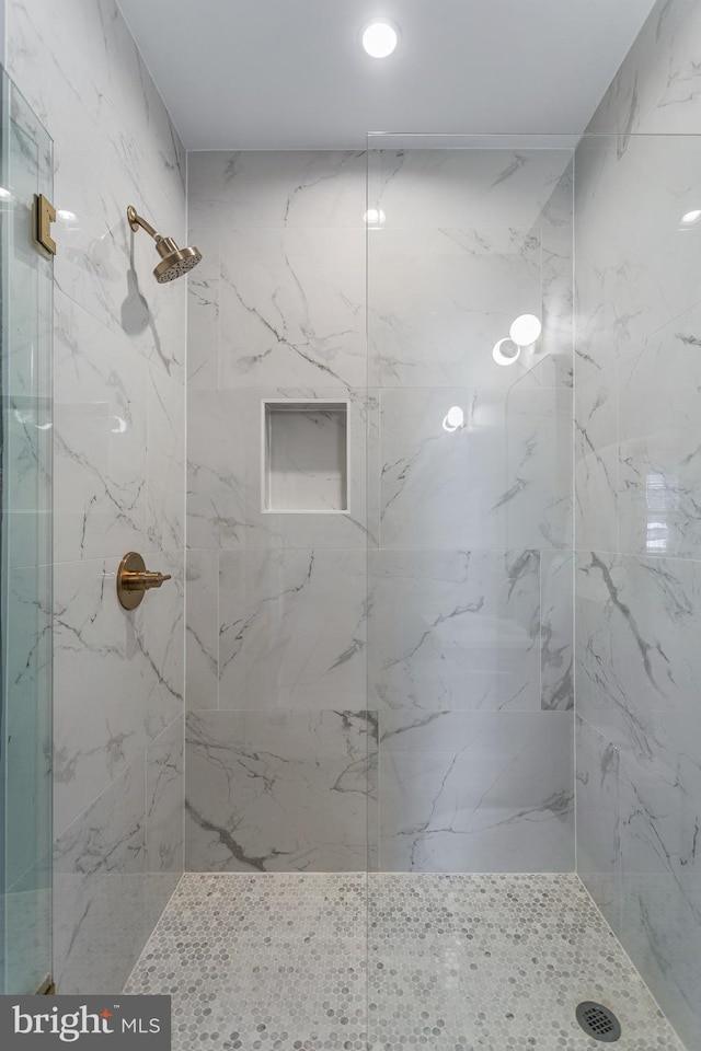 bathroom featuring a marble finish shower