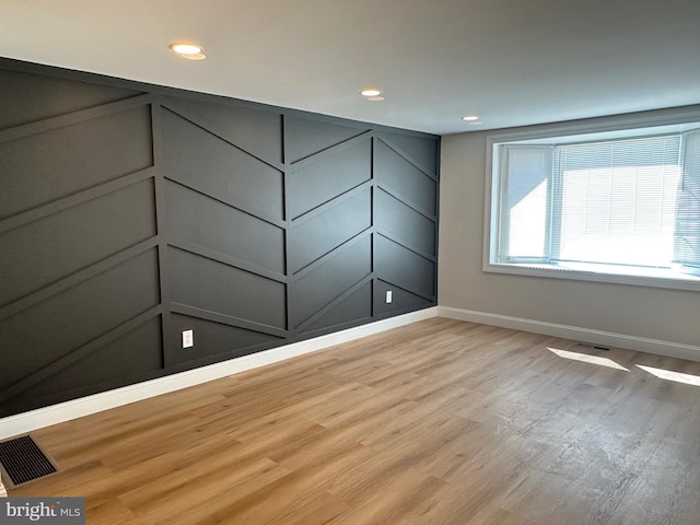 empty room with visible vents, baseboards, and light wood-style floors