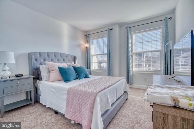 bedroom featuring baseboards and light carpet