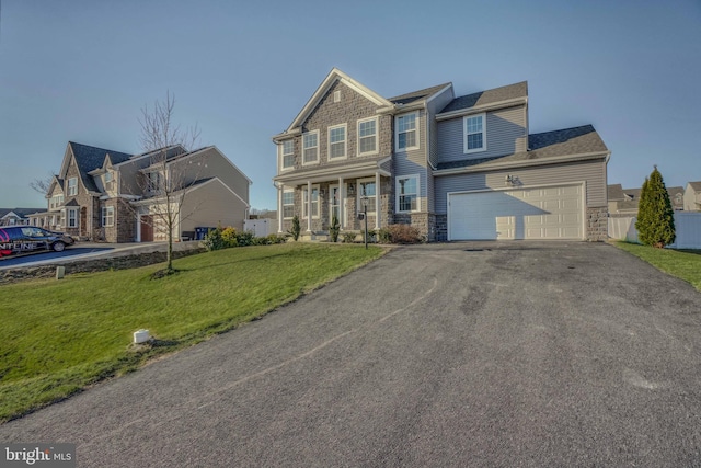 craftsman house with aphalt driveway, a garage, a front lawn, and fence