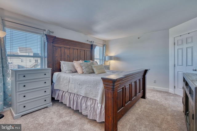 bedroom with light carpet and baseboards