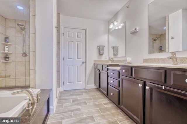 bathroom with double vanity, a tub to relax in, a tile shower, and a sink