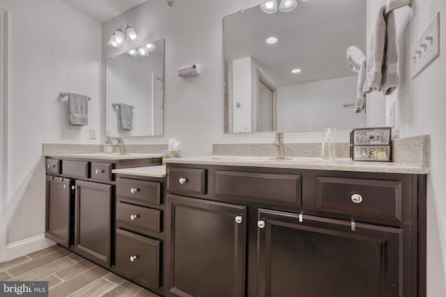 bathroom featuring baseboards, recessed lighting, vanity, and wood finish floors