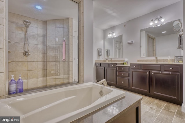 bathroom with a sink, a garden tub, double vanity, and a tile shower