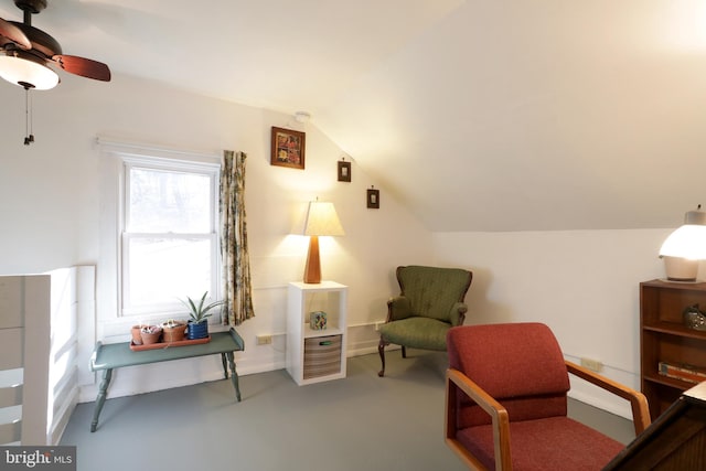 sitting room featuring concrete floors, a ceiling fan, and vaulted ceiling