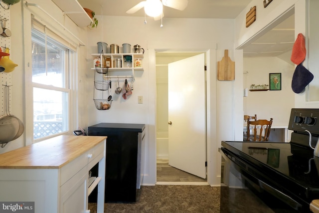 kitchen featuring black electric range oven, wood counters, white cabinetry, carpet floors, and ceiling fan