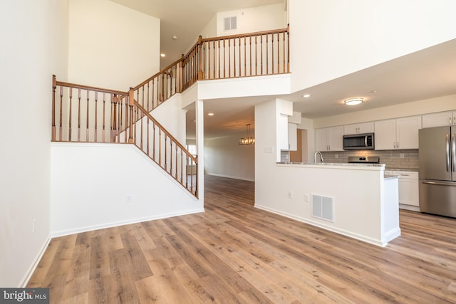 kitchen featuring visible vents, appliances with stainless steel finishes, white cabinetry, and light wood-type flooring