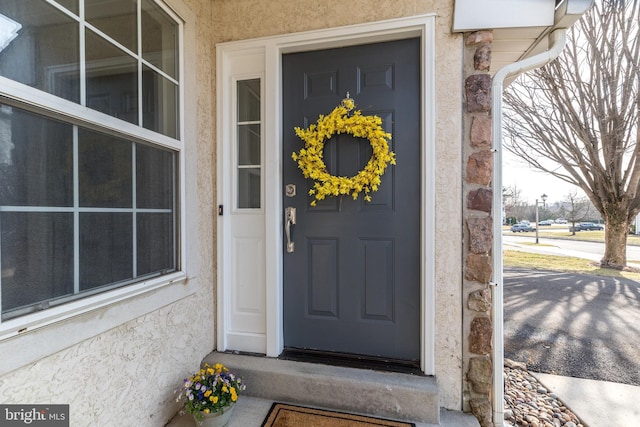 view of exterior entry with stucco siding