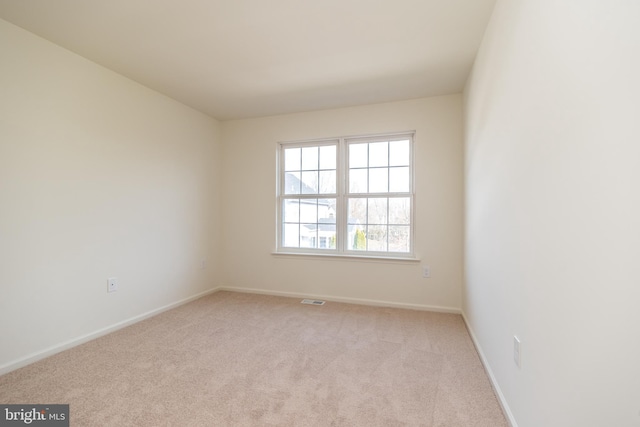 empty room with visible vents, carpet floors, and baseboards