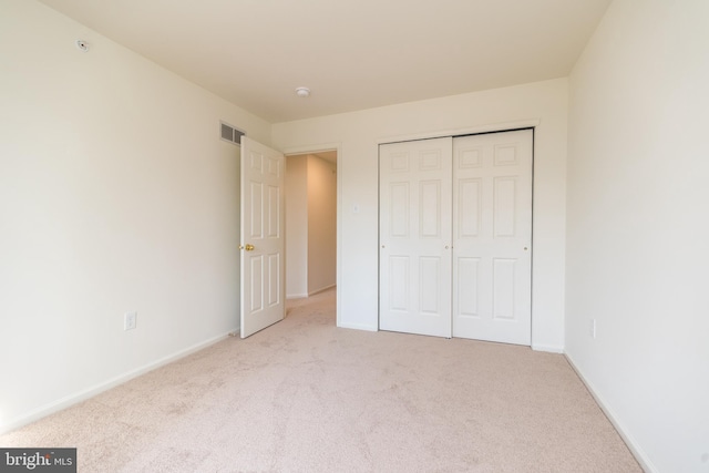 unfurnished bedroom with visible vents, baseboards, carpet, and a closet