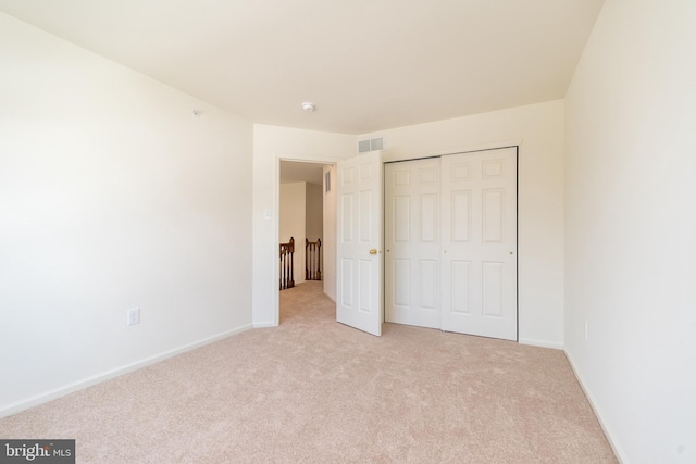 unfurnished bedroom with light colored carpet, visible vents, and baseboards