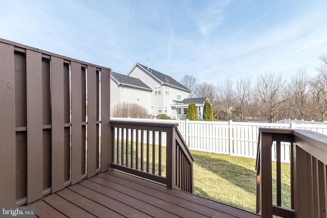 wooden terrace featuring a lawn, a residential view, and a fenced backyard