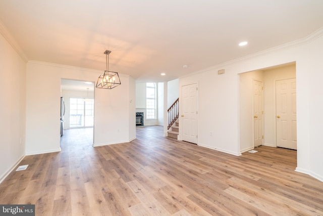 unfurnished dining area with stairway, light wood-style floors, baseboards, and ornamental molding