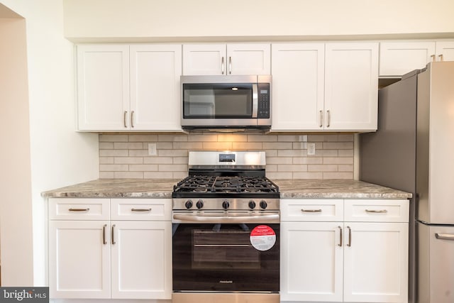 kitchen featuring tasteful backsplash, appliances with stainless steel finishes, and white cabinets