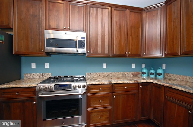 kitchen featuring appliances with stainless steel finishes and light stone countertops