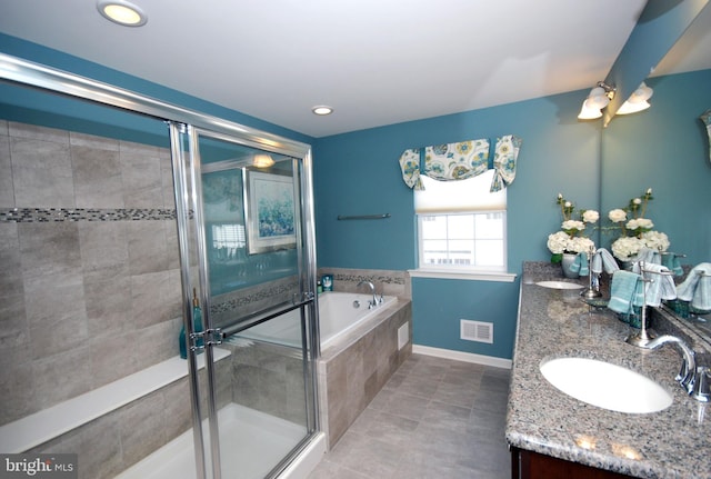 full bath with double vanity, visible vents, a shower stall, and a sink