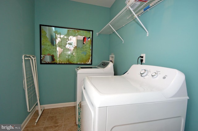 laundry area featuring baseboards, independent washer and dryer, laundry area, and tile patterned flooring