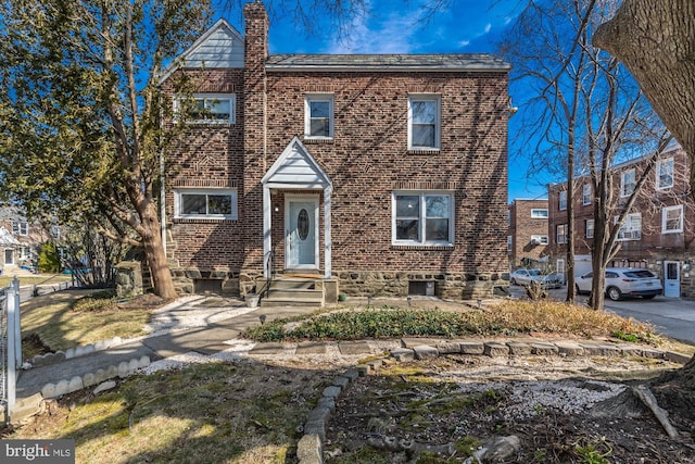 view of front of home with brick siding and a chimney