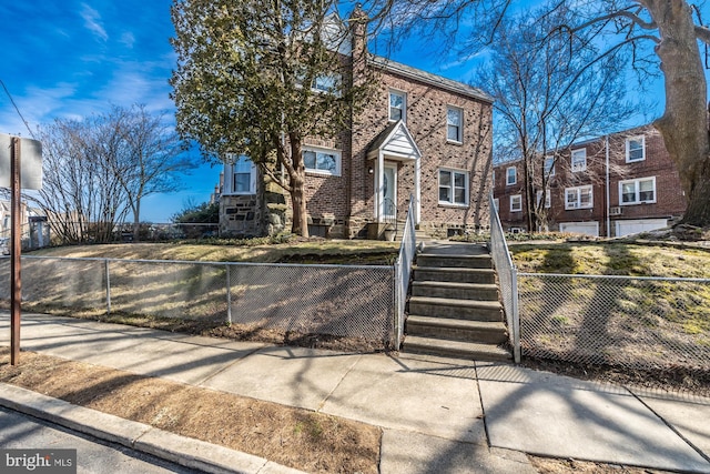 view of front of home featuring a fenced front yard and brick siding