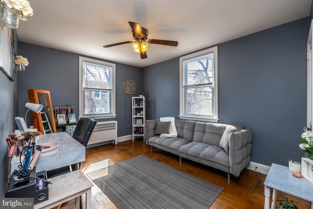 office featuring radiator, a ceiling fan, and baseboards