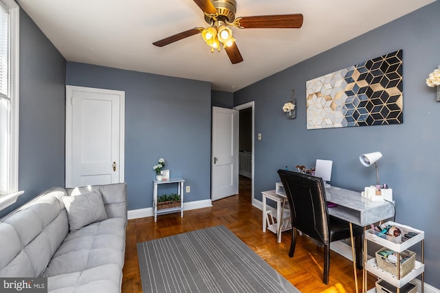 office space featuring baseboards and a ceiling fan