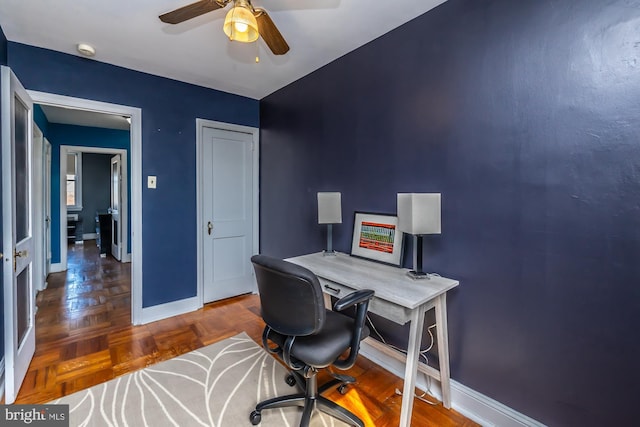 home office with a ceiling fan and baseboards