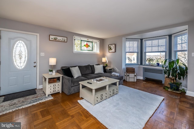 living room with a healthy amount of sunlight, radiator, and baseboards