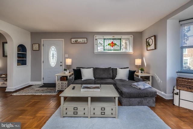 living room featuring arched walkways and baseboards