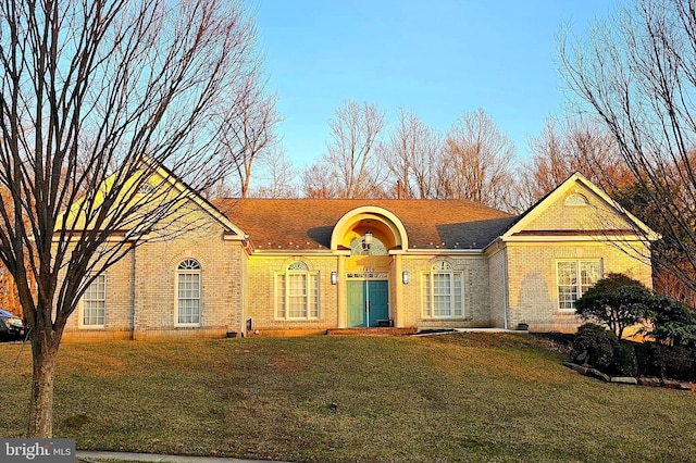 view of front of home with a front lawn and brick siding