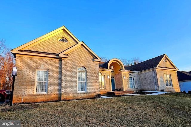 traditional-style home featuring brick siding and a front yard