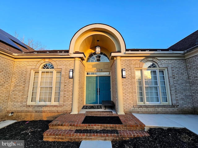 view of exterior entry with brick siding