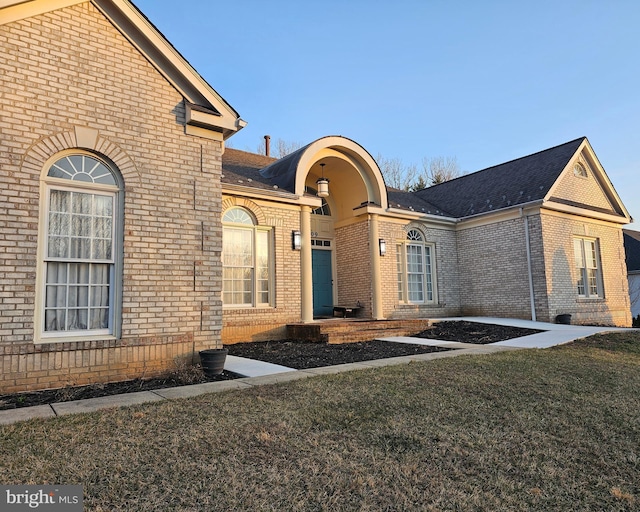 view of front of property featuring brick siding and a front yard