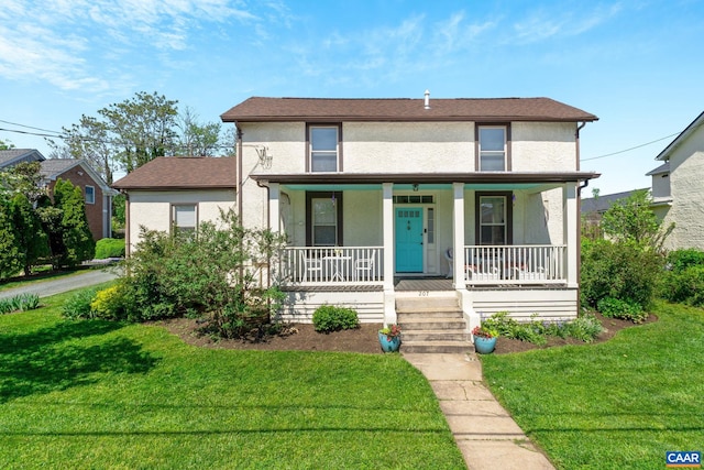 view of front of house with a front yard, covered porch, and stucco siding