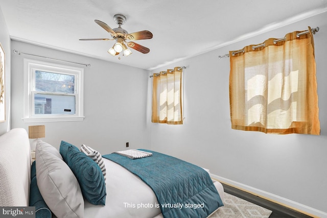 bedroom with wood finished floors, baseboards, and ceiling fan