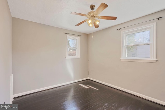 empty room featuring wood finished floors, baseboards, and ceiling fan