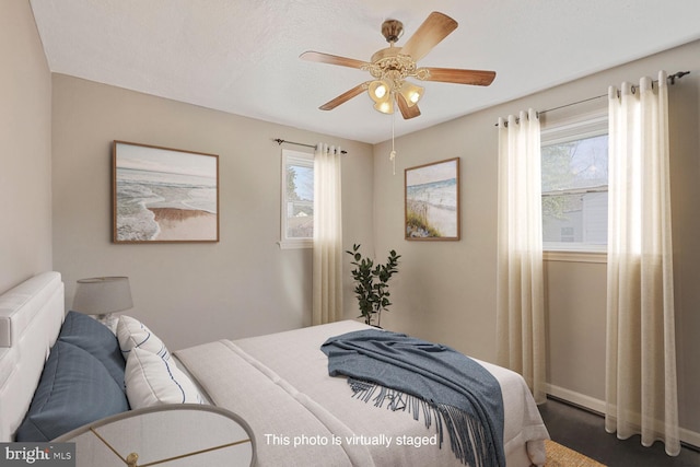 bedroom with baseboards, multiple windows, and a ceiling fan