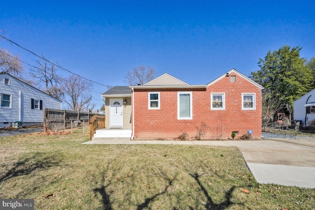 view of front of home featuring a front lawn, fence, and brick siding