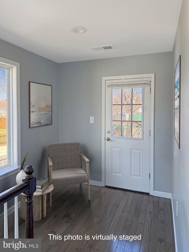 living area featuring visible vents, baseboards, and dark wood-type flooring