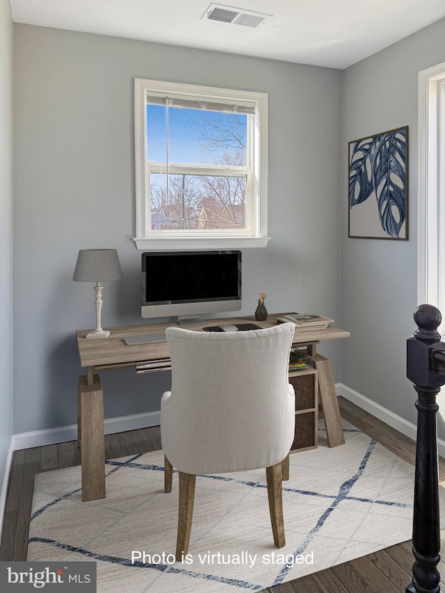 office area featuring wood finished floors, visible vents, and baseboards