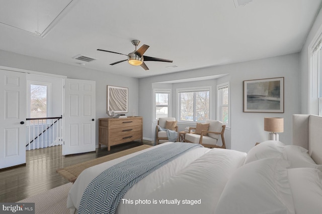 bedroom featuring attic access, multiple windows, wood finished floors, and visible vents