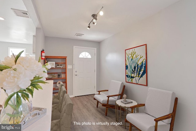 foyer entrance with plenty of natural light, wood finished floors, and visible vents