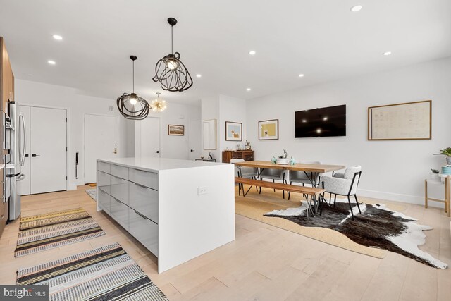 kitchen with recessed lighting, light countertops, light wood-style floors, modern cabinets, and a center island