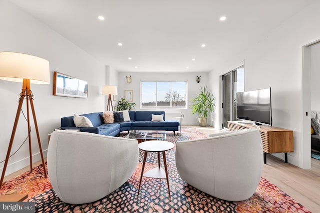 living room with recessed lighting, light wood-type flooring, and baseboards