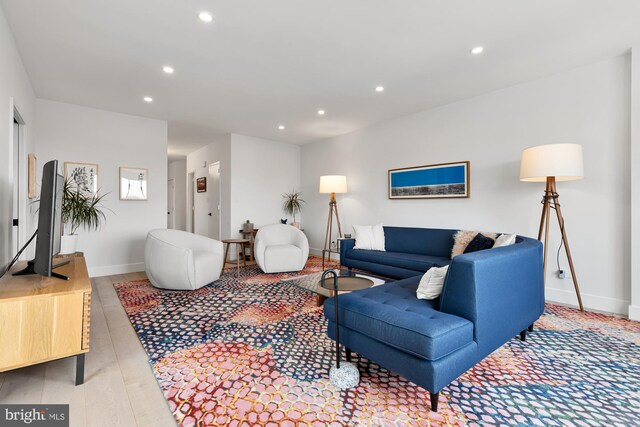 living area with recessed lighting, light wood-type flooring, and baseboards