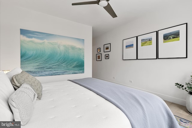 bedroom with a ceiling fan, wood finished floors, and baseboards