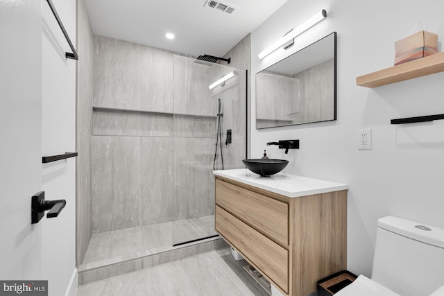 full bath featuring visible vents, toilet, vanity, and a walk in shower